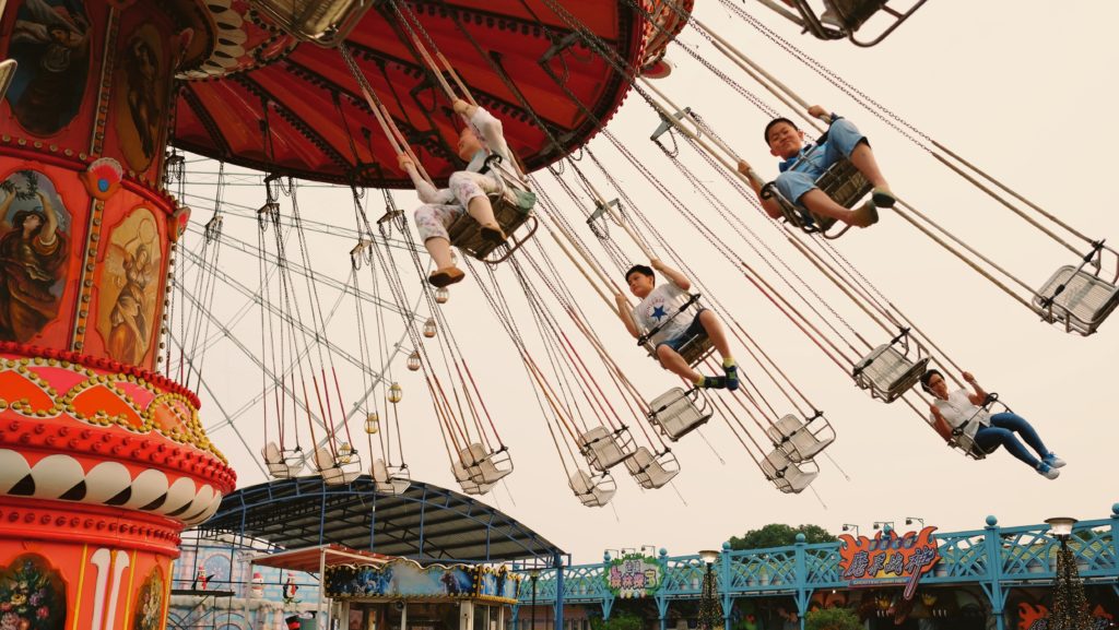 a photo of carnival people on swings